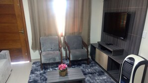 A living room with a sofa, a coffee table, a TV, and a heater. - CORREA PEREIRA RESIDENTIAL APARTMENT 3, sleeps up to 11 people, 3 bedrooms (CANELA)