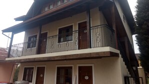 A two-story building with a balcony and a wooden door. - CORREA PEREIRA RESIDENTIAL APARTMENT 3, sleeps up to 11 people, 3 bedrooms (CANELA)