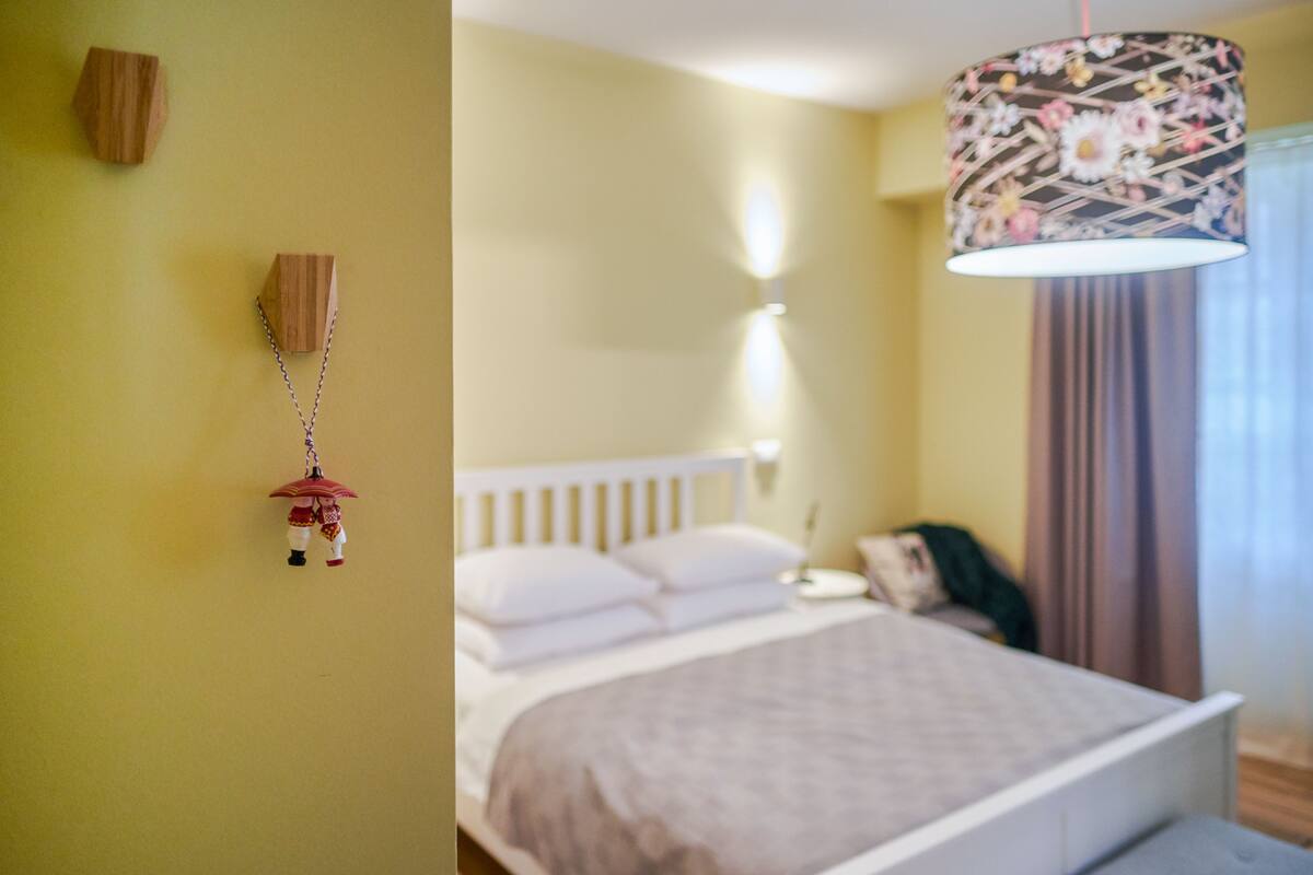 Ein Schlafzimmer mit einem Bett, einer Pendelleuchte und einem an der Wand befestigten Gegenstand.