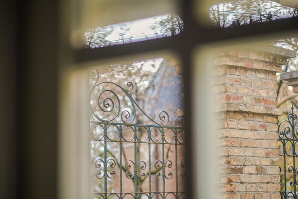 Secure entrance to a property, featuring a wrought iron gate with intricate scrollwork.