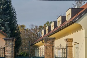 Stylish residential building with brick and stucco exteriors, featuring balconies and symmetrically arranged windows.
