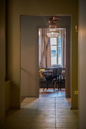 Enter a spacious living area with a sofa, chair, and chandelier.