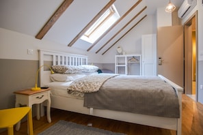 Relax in this serene bedroom with a skylight, comfortable bed, and ample storage.