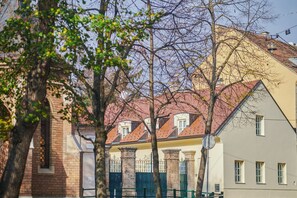 A traditional European building with a brick facade, a red-tiled roof, and a green gate. - Peacock Boutique Apartments (Zagreb)