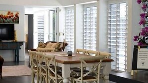 Un comedor con mesa y sillas de madera, un televisor y un cuadro en la pared.