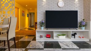Un saló amb televisió de pantalla plana sobre una paret de maó blanc, un sofà i una taula de centre.