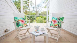 A cozy room with two rocking chairs, a table with a magazine, a teapot, and a cup. - Port Douglas Mirage Villa 123 (Port Douglas)