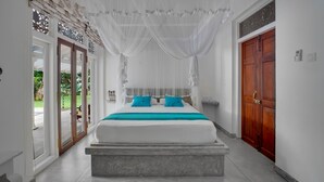 A bedroom with a bed, a wooden door, and a view of the outdoors. - Tara Garden Tropical Villa with Private Pool & Friendly Staff Near Beach (Dharga Town)