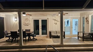 An outdoor patio area with a dining table and chairs, a sofa, and a ceiling fan. - Beautiful house and great neighborhood! (Marco Island)