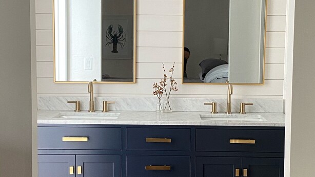 A bathroom with two sinks, dark blue cabinets, gold handles, and white marble countertops. - Beautiful house and great neighborhood! (Marco Island)