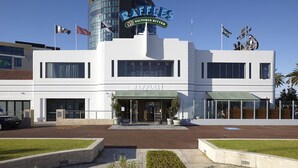 A modern building with a sign reading "RAFFLES" and "Victoria Bitter" on the facade.