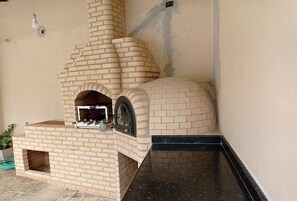 A brick-built outdoor oven with a black countertop and a window, likely for pizza or cooking. - Beautiful house in Buzios!!!! (Armação dos Búzios)