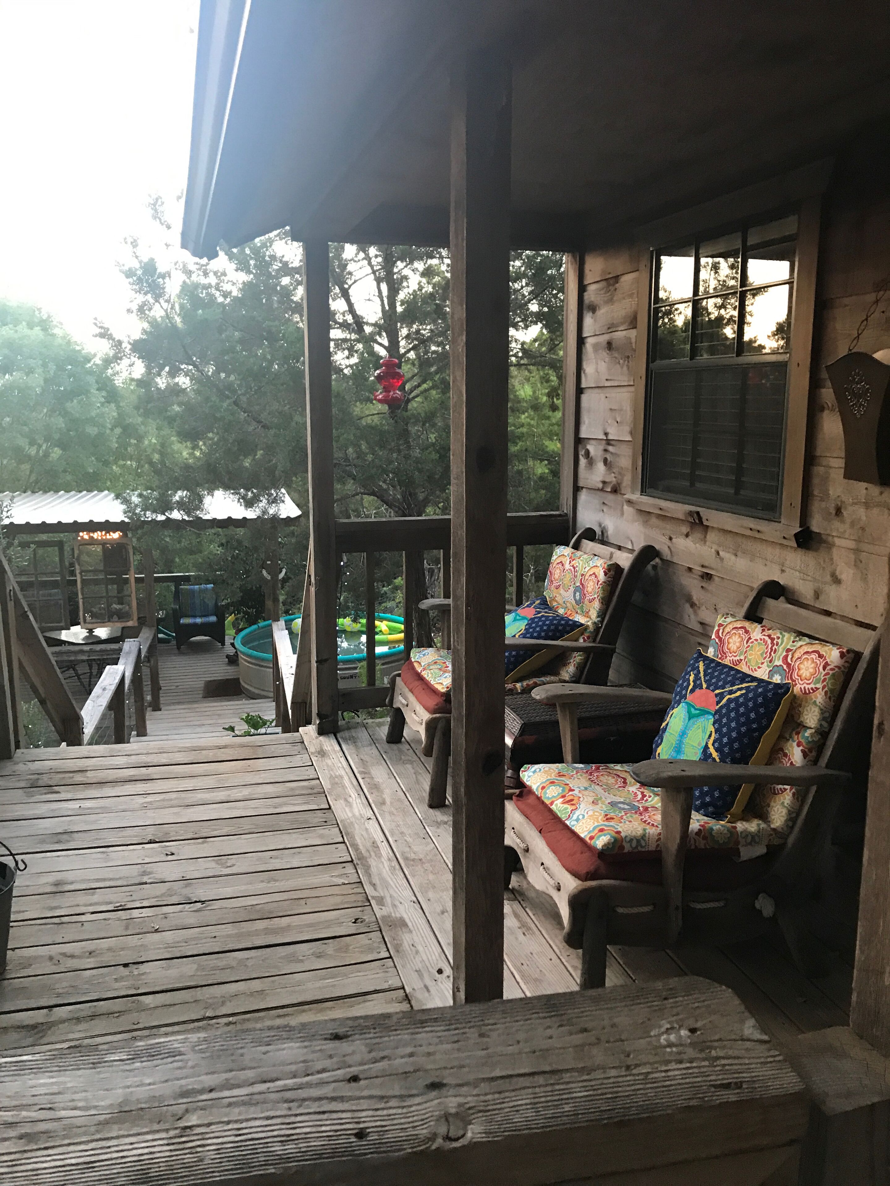 Une terrasse en bois avec un espace salon extérieur et une piscine.