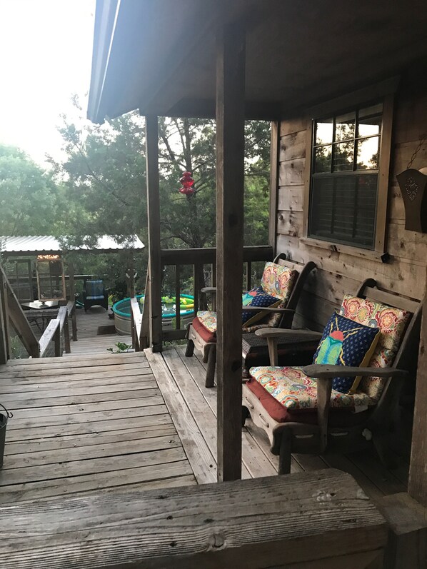 A wooden deck with outdoor seating and a pool area.