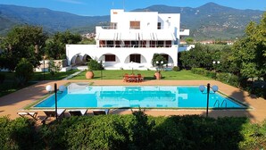 Une villa moderne dotée d’une piscine, d’un espace extérieur aménagé et offrant une vue sur les montagnes.