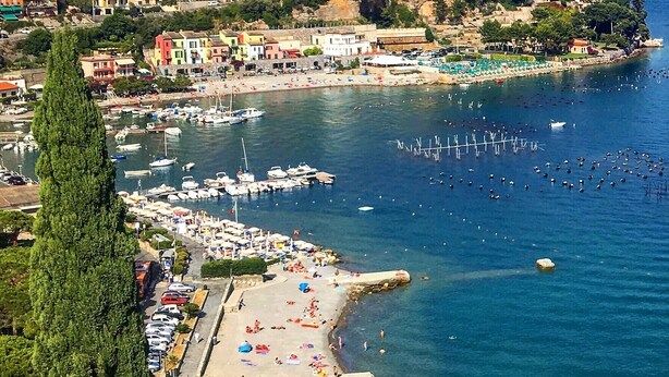 Une ville côtière dotée d’un port de plaisance, d’une plage et de bâtiments.