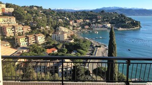 Une ville côtière avec des bâtiments, un port de plaisance et une vue sur la mer et les montagnes.