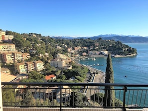 Une ville côtière avec des bâtiments, un port de plaisance et une vue sur la mer et les montagnes.