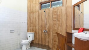 Un baño con cabina de ducha de madera, inodoro blanco y lavabo con espejo.
