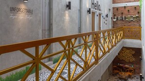 Un intérieur moderne avec un escalier, une enseigne « Bonjour » et une autre qui dit « INOUBLIABLE ».