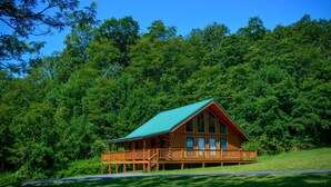 A wooden cabin with a green roof, surrounded by dense forest. - ✧Royale Cabin- KING bed, hot tub, NO CLEANING FEE (Dryfork)