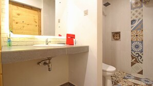 A bathroom with a sink, mirror, and toilet. - RedDoorz near Pojok Beteng Prawirotaman (Yogyakarta)