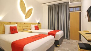 A hotel room with two beds, a wooden headboard, a flat-screen TV, and a large window with curtains. - RedDoorz near Pojok Beteng Prawirotaman (Yogyakarta)