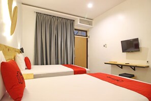 A hotel room with two beds, a TV mounted on the wall, and a window with curtains. - RedDoorz near Pojok Beteng Prawirotaman (Yogyakarta)