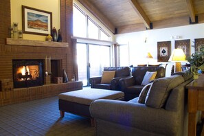 Una sala de estar acogedora con chimenea, sofás de cuero y un ventanal grande.