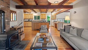 Un salón acogedor con chimenea, una mesa de centro de vidrio y un sofá.