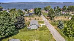 A residential area with a house featuring a front yard, a driveway, and a view of a lake. - Beautiful Cottage Overlooking Bear Lake (Bear Lake)