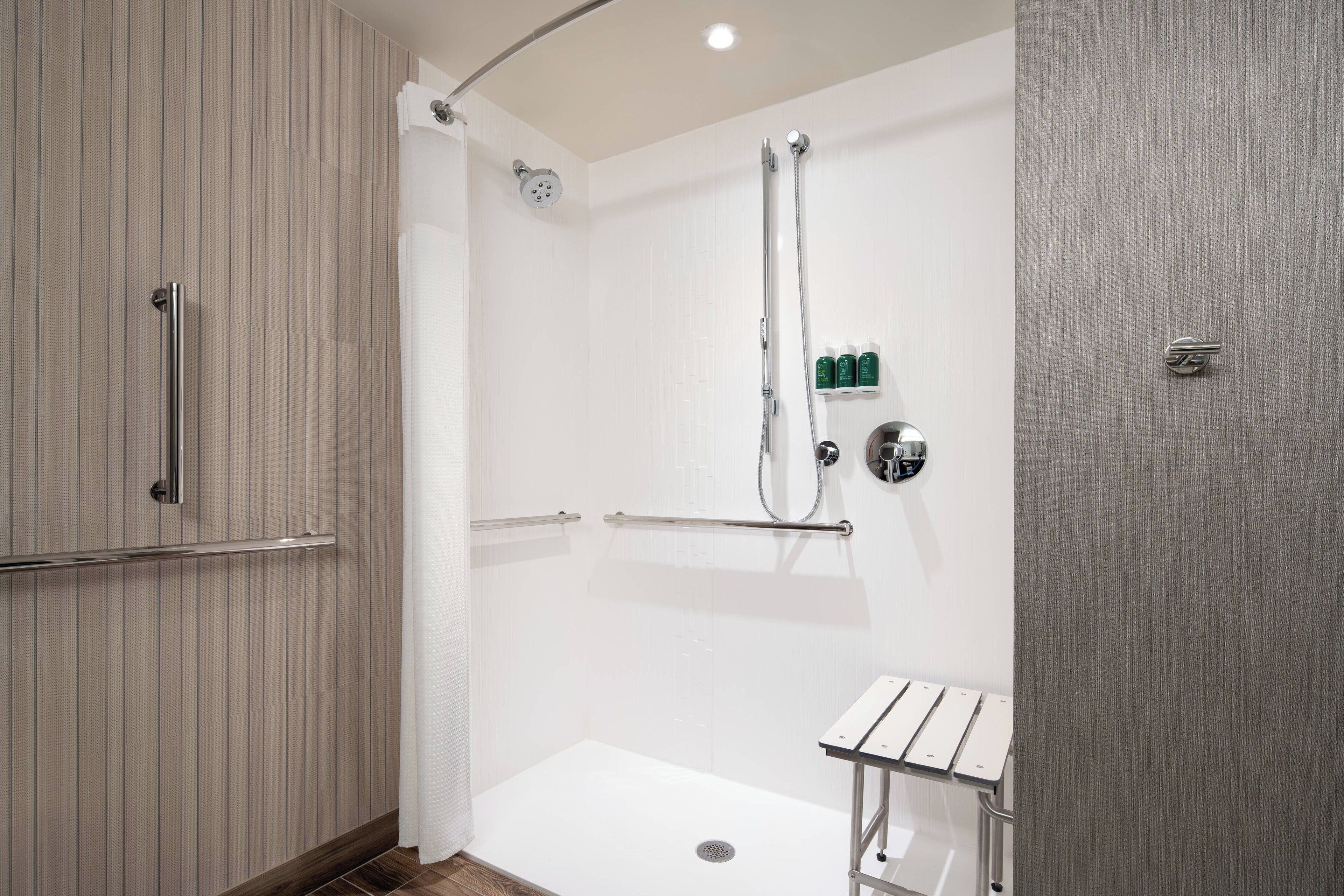A modern bathroom with a shower, a toilet, and a sink.