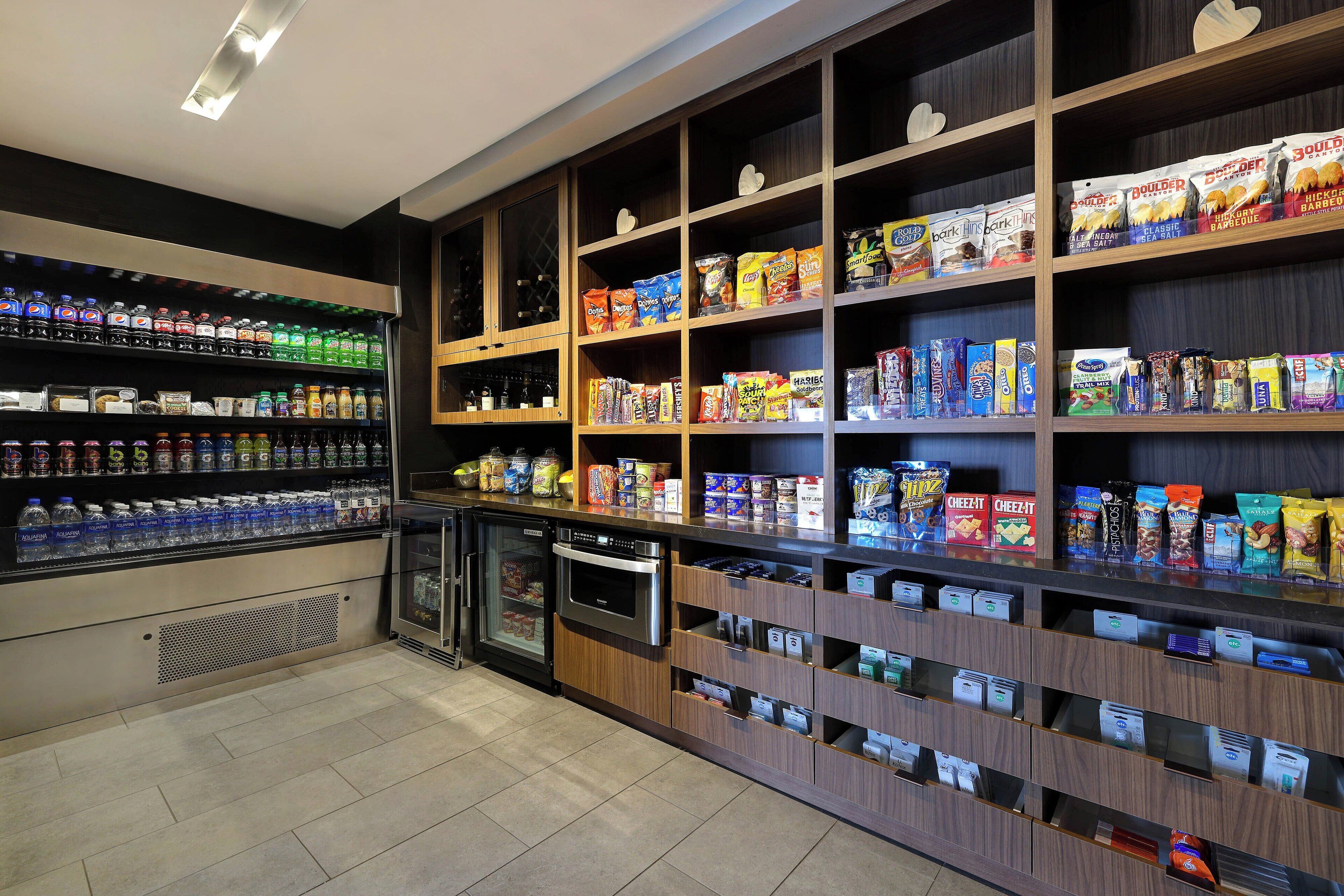 Un quiosco autoservicio de bebidas y aperitivos con diversas opciones de bebidas y paquetes de snacks.