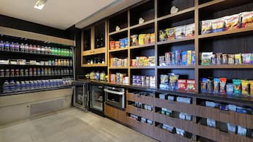 Un quiosco autoservicio de bebidas y aperitivos con diversas opciones de bebidas y paquetes de snacks.