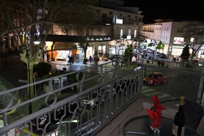 Een nachtzicht van een stadsplein met winkels en een voetgangersgebied.