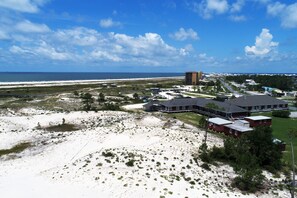 Ein Küstenhotel mit mehreren Gebäuden, Blick auf den Strand und wolkenlosem Himmel.