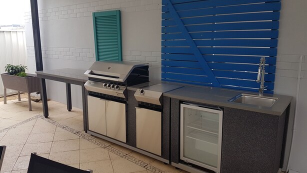 A compact outdoor kitchen with a built-in grill, a sink, and a small refrigerator. - Sanctuary for family and friends (Balcatta)