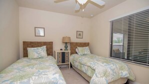 A bedroom with two single beds, a nightstand with a lamp, and a window with blinds. - Indulge in Endless Activities: Tennis, Golf, Pools, and More at Treviso Bay (Naples)
