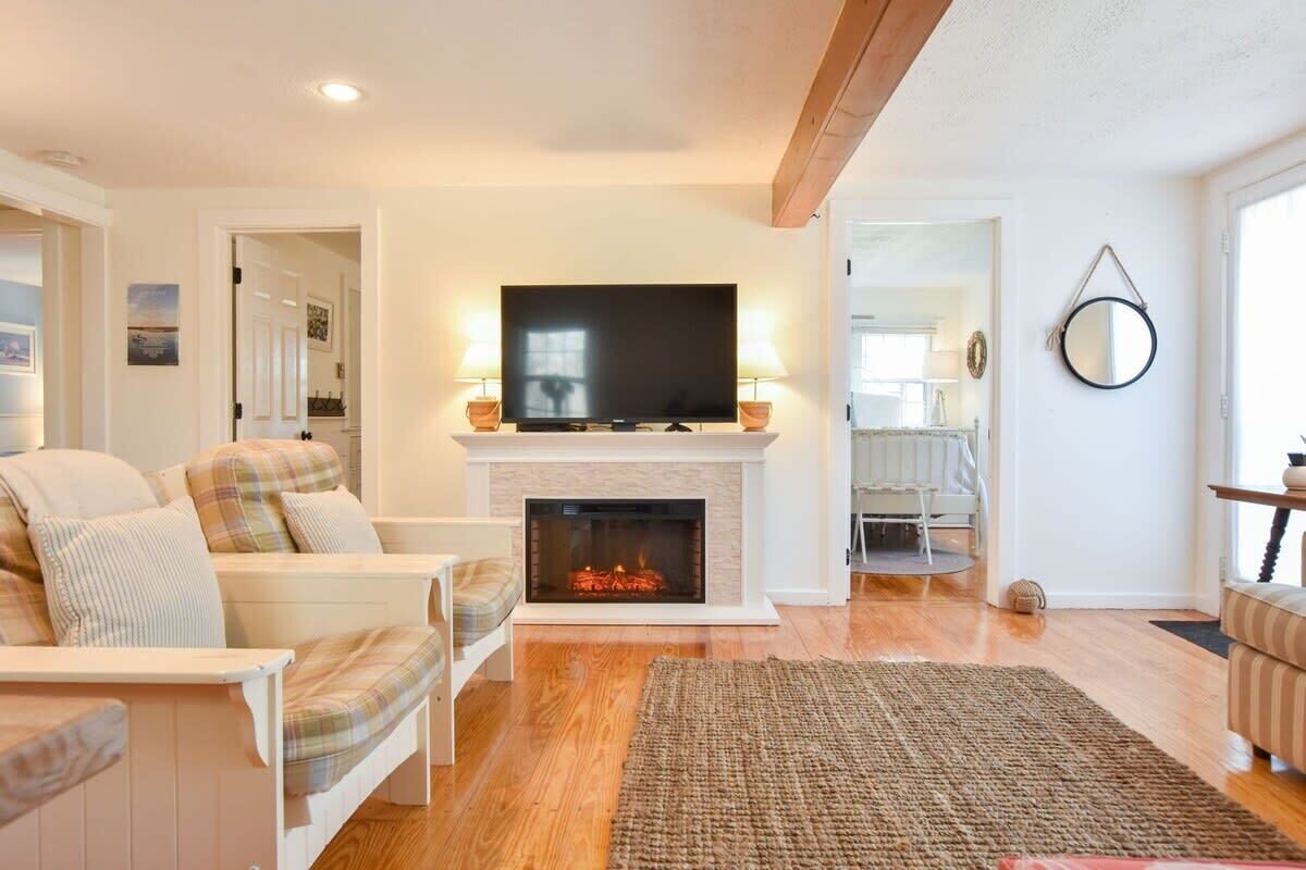 A living room with a fireplace, a television, and a sofa.