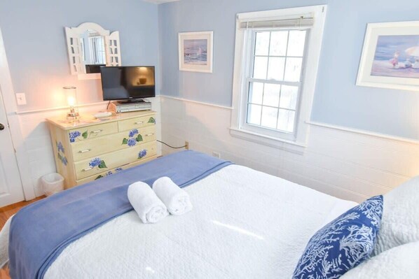 A bedroom with a bed, a dresser, a television, and a window. - Lovely Home Minutes from Beach in Chatham! (Chatham)