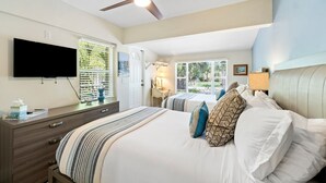 A bedroom with two beds, a ceiling fan, a TV, and a window with blinds. - BY THE SEA VACATION VILLAS 3 BED POOL/ BEACH AT END OF STREET (Lauderdale-by-the-Sea)