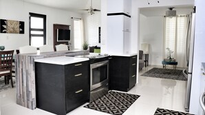 A modern kitchen with a central island, built-in oven, and stainless steel appliances. - Spectacular Views at the Lakehouse Paradise!! (Toa Baja)