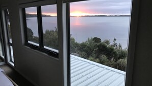 Huone, josta avautuu näkymä järvelle auringonlaskun aikaan.