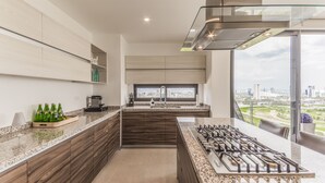 Una cocina moderna con una isla grande, electrodomésticos integrados y vistas de la ciudad.