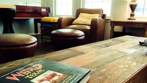 A room with a wooden table, a leather chair, and a book titled "Weird Texas" on the table.