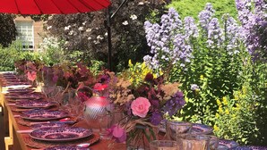 A long dining table set with plates, glasses, and a vase of flowers, under a red umbrella, with a garden in the background. - Historic 2000 Acre Country Estate in Rural Ayrshire, near Troon and Prestwick. (Hurlford)