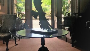 A lobby with a glass table, chairs, and a large window with a silhouette of a bird. - Historic 2000 Acre Country Estate in Rural Ayrshire, near Troon and Prestwick. (Hurlford)