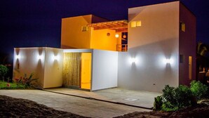 Una casa moderna de dos pisos con techo plano y puerta de madera.