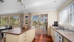 A kitchen with a wooden countertop, a dishwasher, and a view of the outdoors.