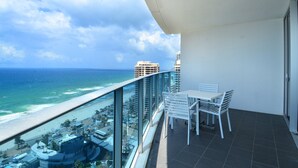 A balcony with a view of the ocean and beach, white chairs, and a glass railing. - Wake Up In Paradise, Luxury Surfers Paradise Apt (Surfers Paradise)